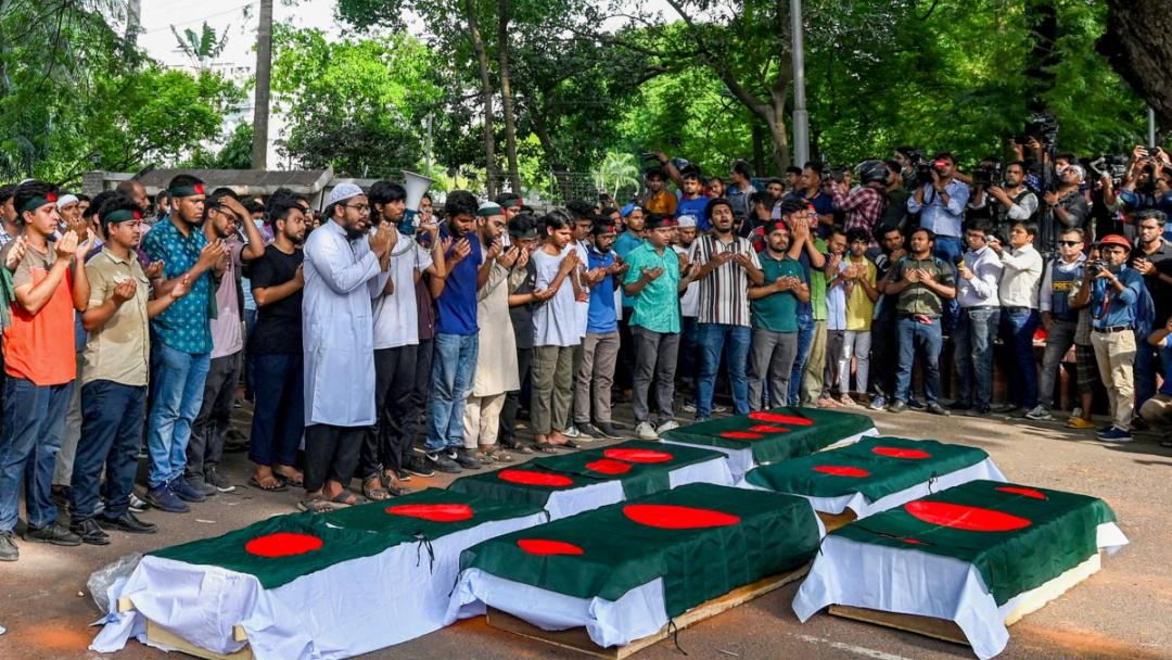 Students protesting against quotas in government jobs offer prayers over symbolic coffins.