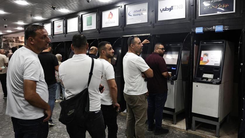 Palestinians withdraw money from ATM's at a bank in the northern Palestinian city of Nablus, in the Israeli occupied West Bank on June 9, 2024.